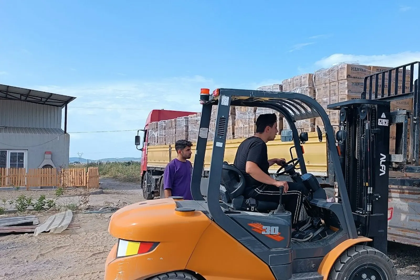 Operario moviendo pallets con montacargas