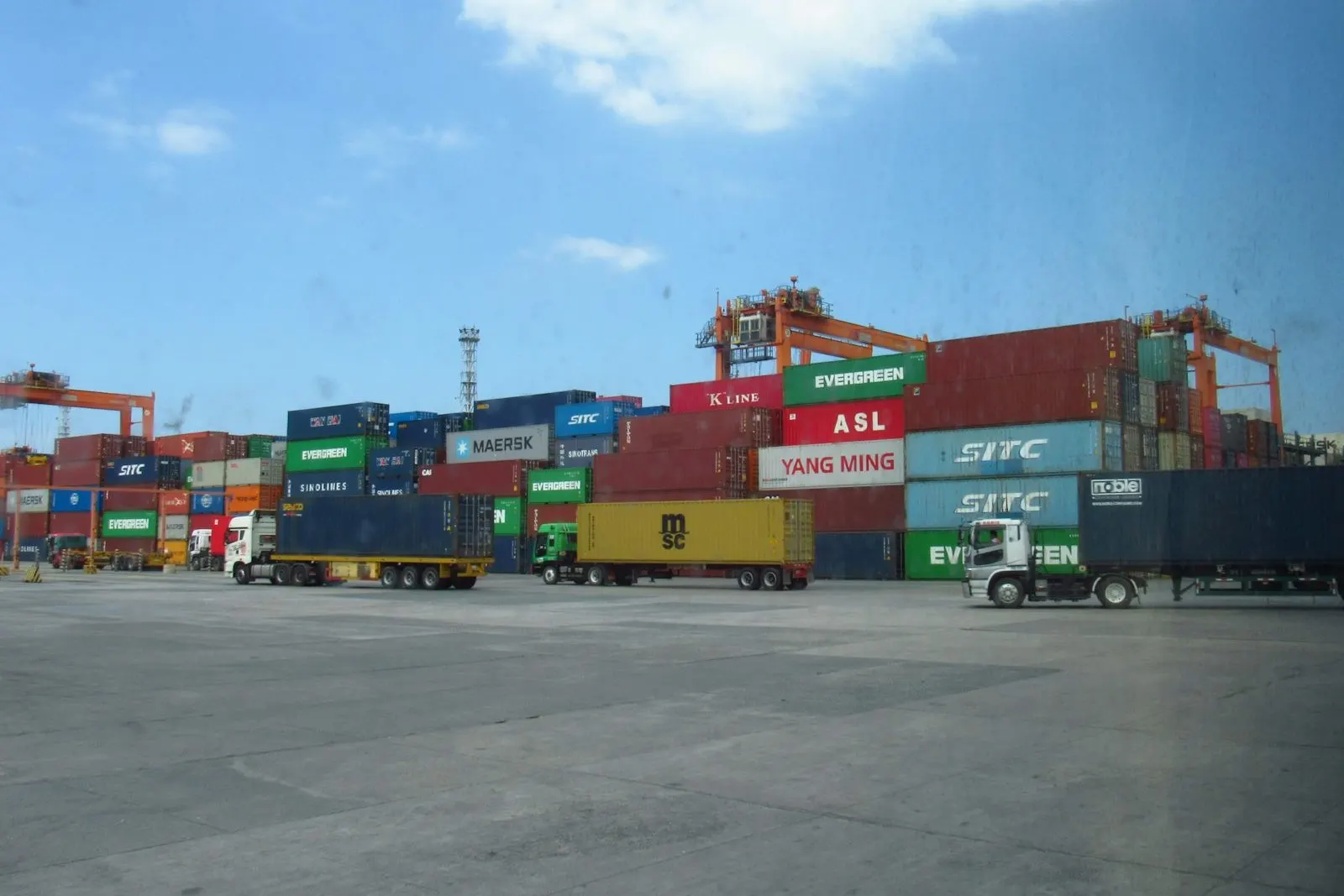 Camiones y contenedores en el patio de operaciones